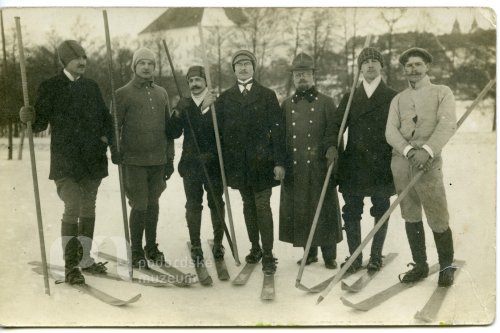 Skupina mužů na lyžích na zamrzlém rybníku Kuchyňka