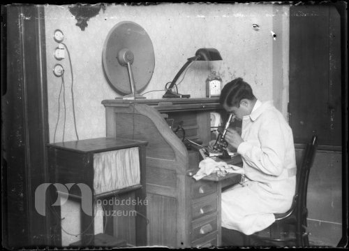 Mladý vědec u stolu s microskopem